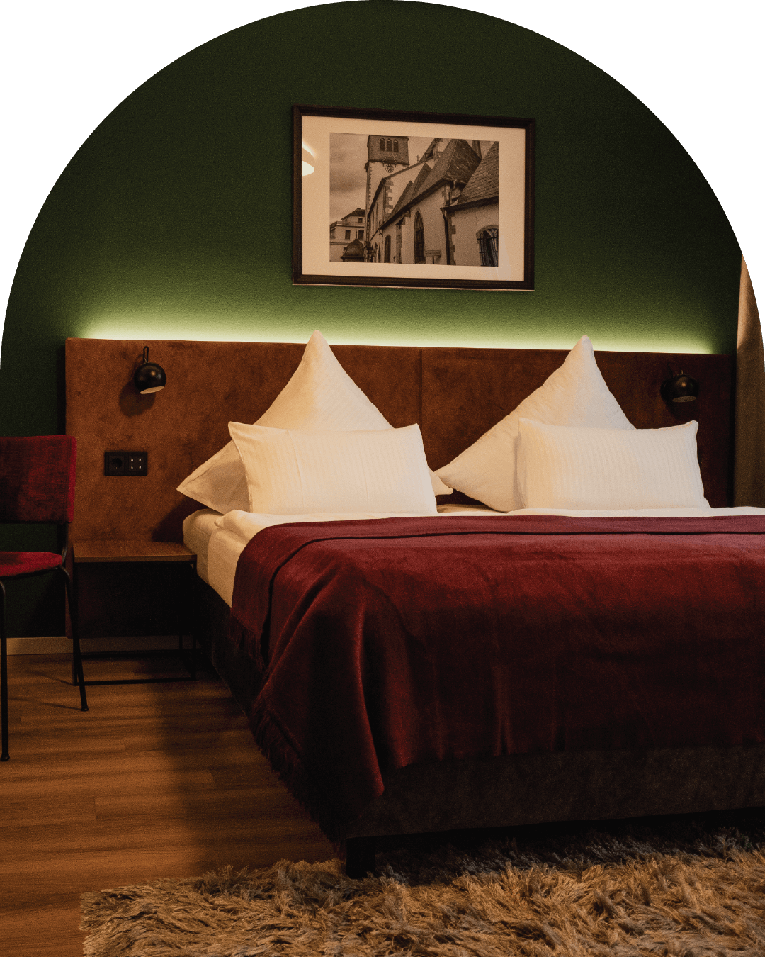 Das-Muehlentor-Restaurant-Hotel-Bad-Kreuznach-Zimmer-Doppelbett-vor-gruener-Wand-mit-dunkelroter-Tagesdecke