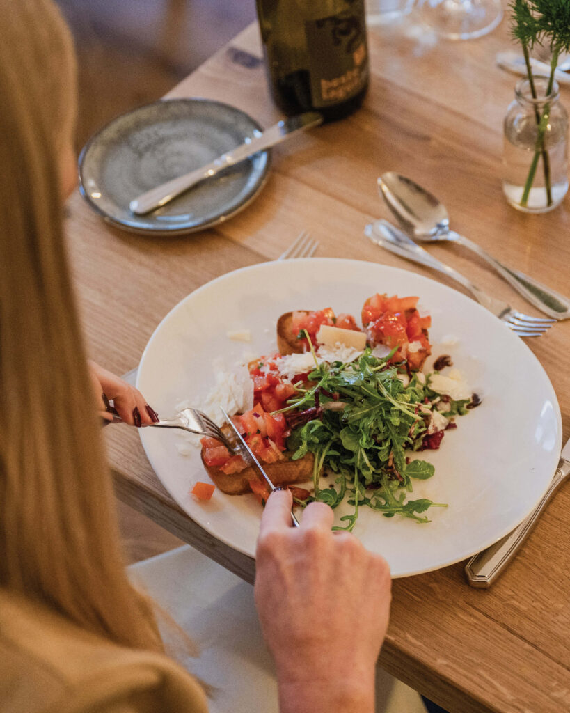 Restaurant-Das-Muehlentor-Schulterblick-auf-den-Tisch-mit-einem-Teller-Bruscetta
